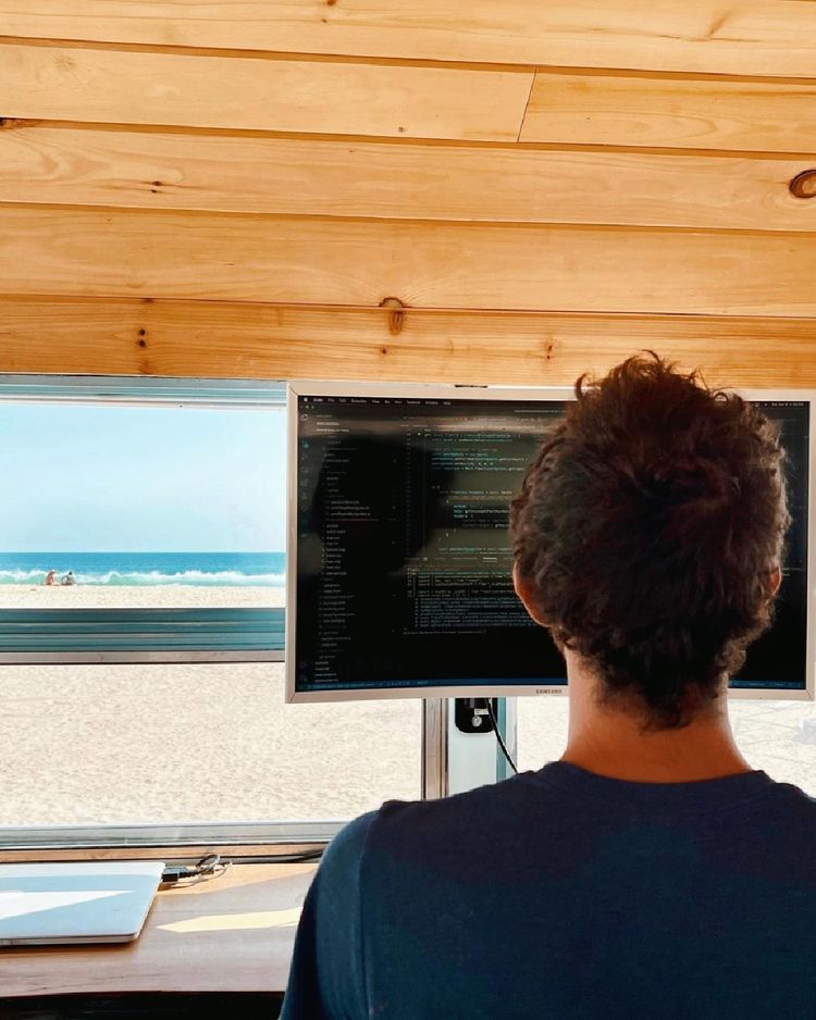 A man working remotely on his computer in an RV. Photo by Instagram user @rootlessliving