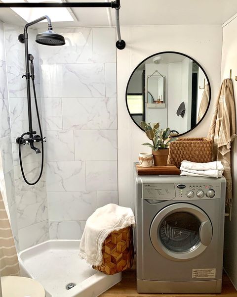 Motorhome bathroom with grey tile and washing machine. photo credit @flyingjsranch