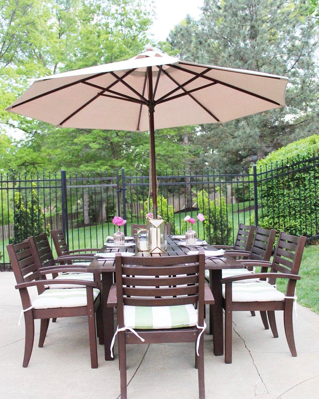 outdoor dining table with pops of color shown with umbrella photo by Instagram user @kateknowleshome