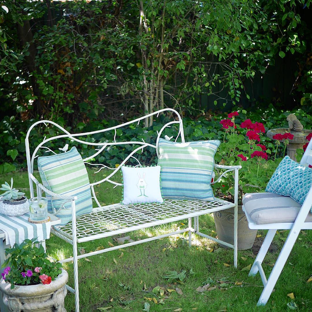 two person bench with pillows on top photo by Instagram user @marieshomeandgarden