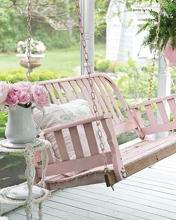 front porch with pink porch swing photo by Instagram user @pennyscallandesign