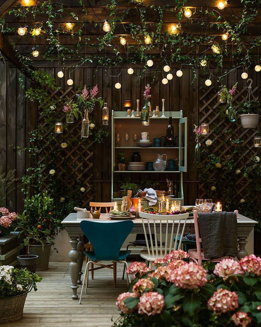 pergola over the top of a small backyard with vines and string lights hanging from it photo by Instagram user @travel.loverxo