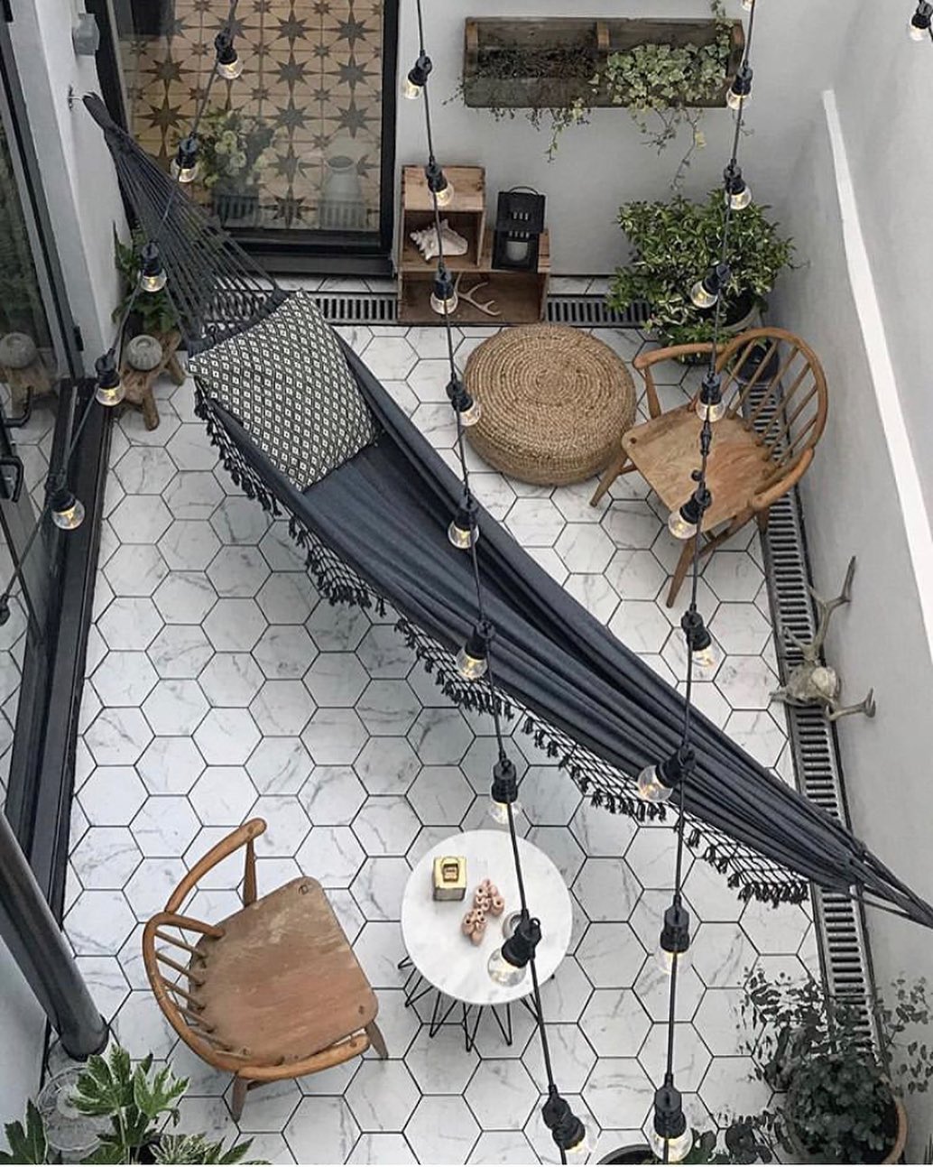 small patio with chairs and a hammock stretched across photo by Instagram user @ravenhawkdesigns