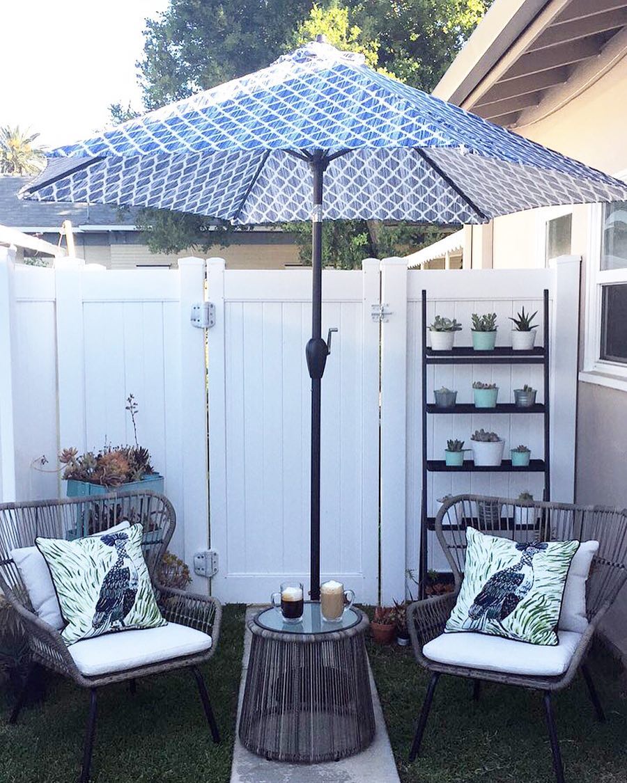 outdoor space with two chairs and small coffee table attached to an umbrella photo by Instagram user @homeobsession