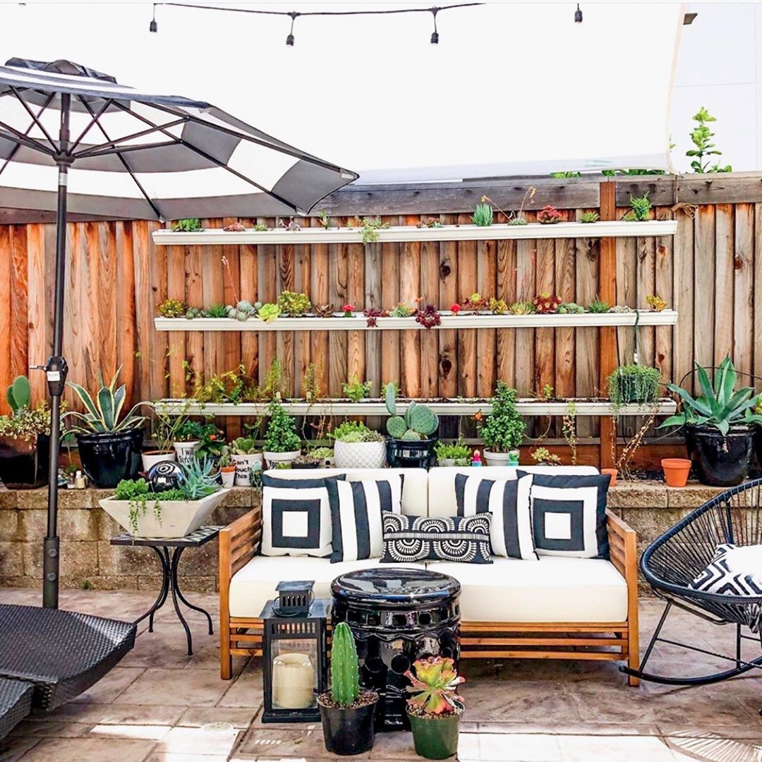 outdoor living space with vertical shelves acting as gardens photo by Instagram user @treehousethreadsblog