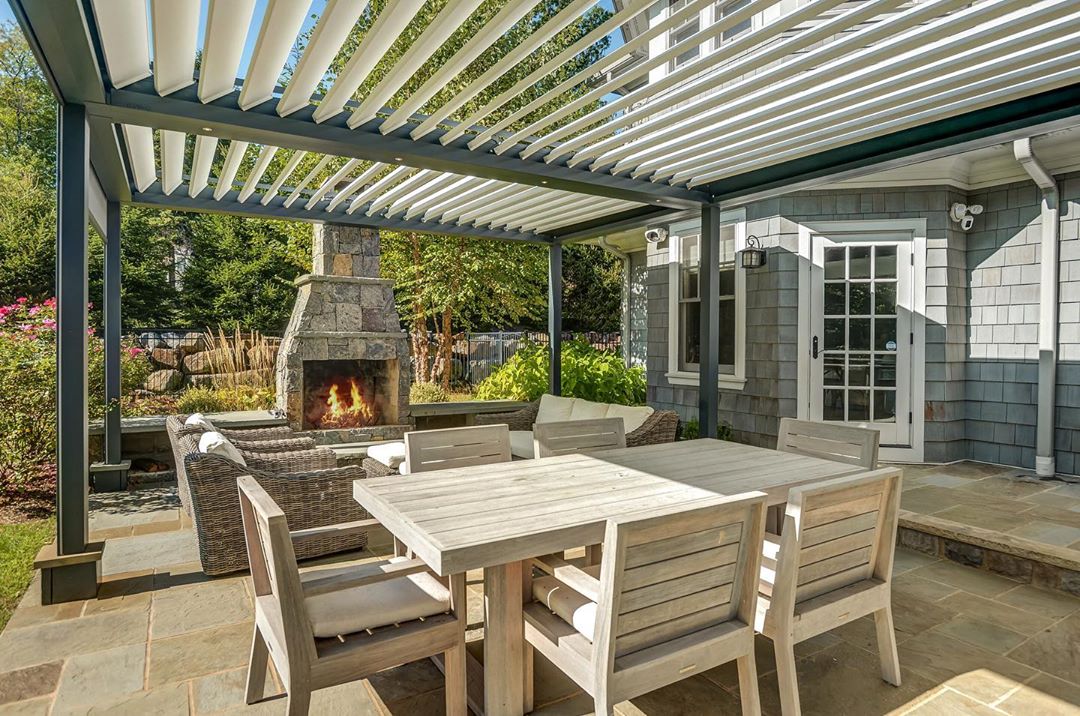 outdoor living space under pergola with fireplace added in photo by Instagram user @paula_sells_victoria