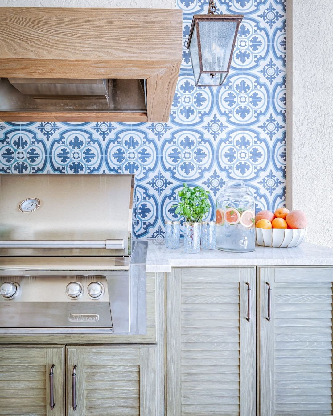 blue and white tile backsplash behind an outdoor grill photo by Instagram user @carriebrighamdesign