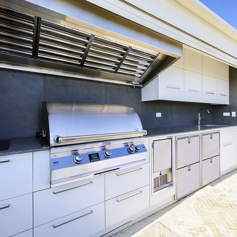 outdoor kitcen with grill and hood with overhead cabinets installed photo by Instagram user @ram_ingber_outdoor_kitchens