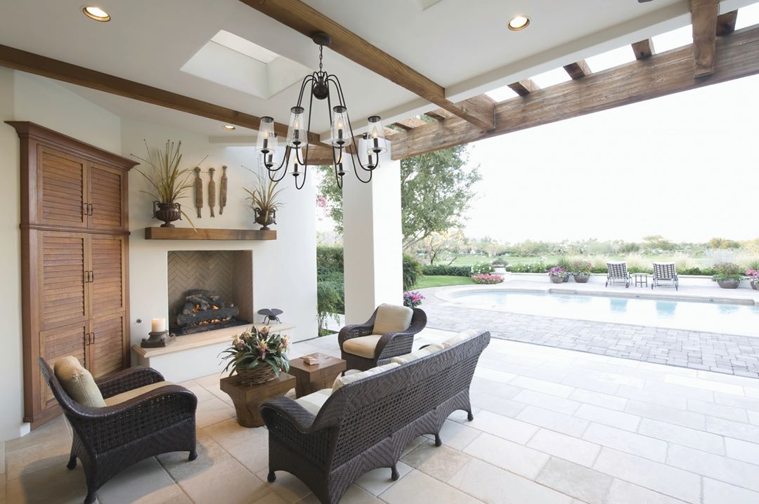 outdoor patio with pool in the background and chandelier hanging from ceiling photo by Instagram user @lightsonline