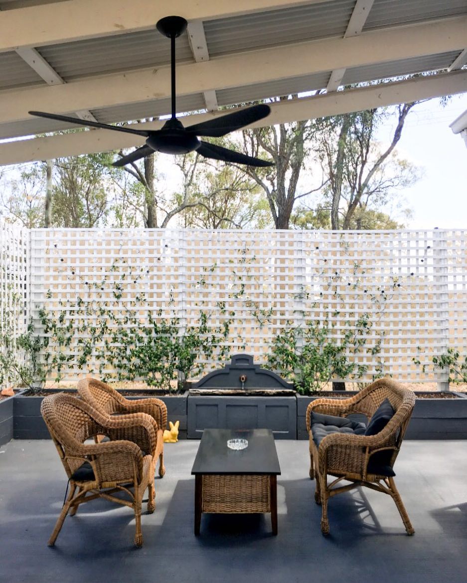 outdoor patio with wicker chairs and black floor with a fan on the ceiling photo by Instagram user @myhuntergatherer