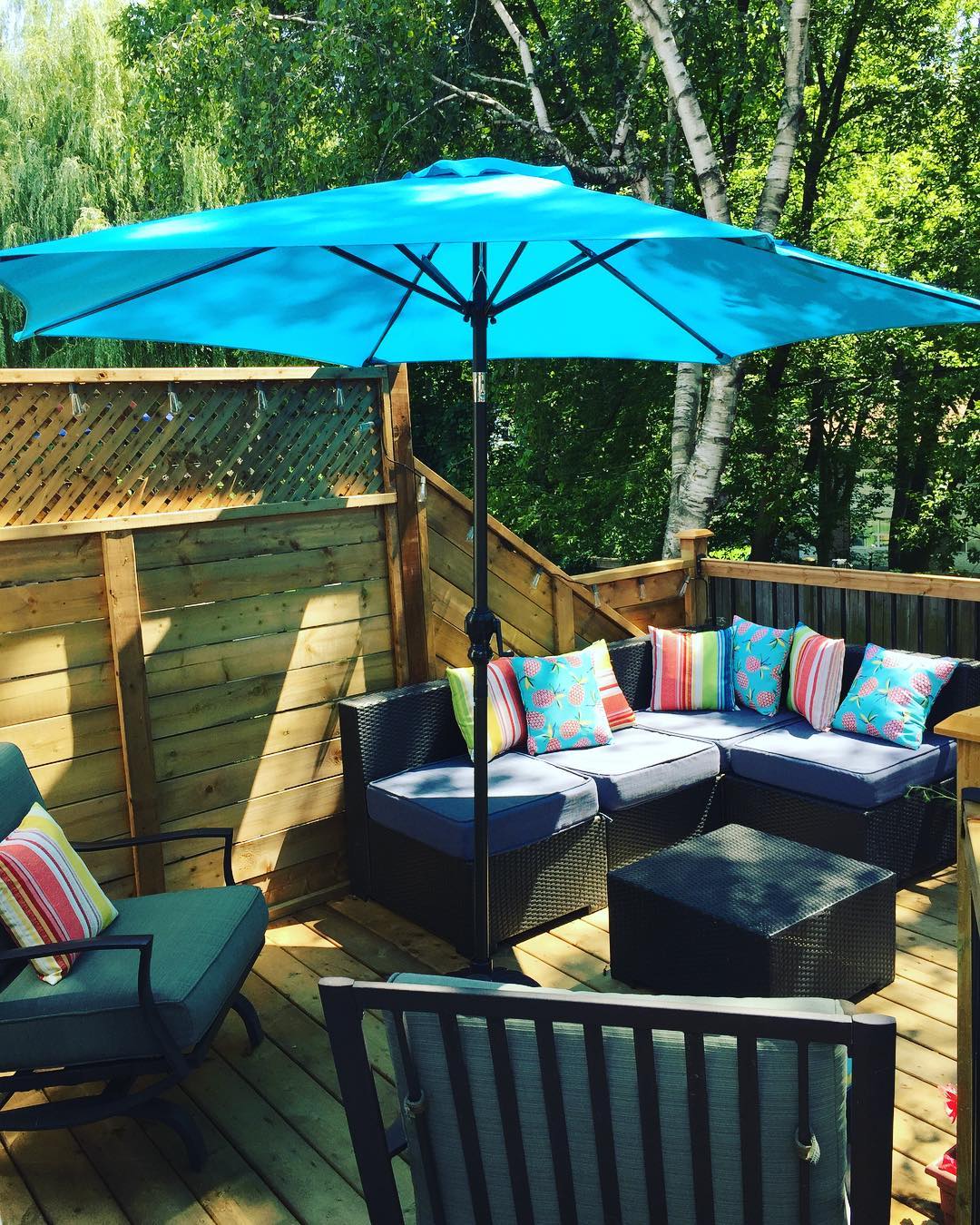 blue umbrella on a deck with seating around photo by Instagram user @gruth3