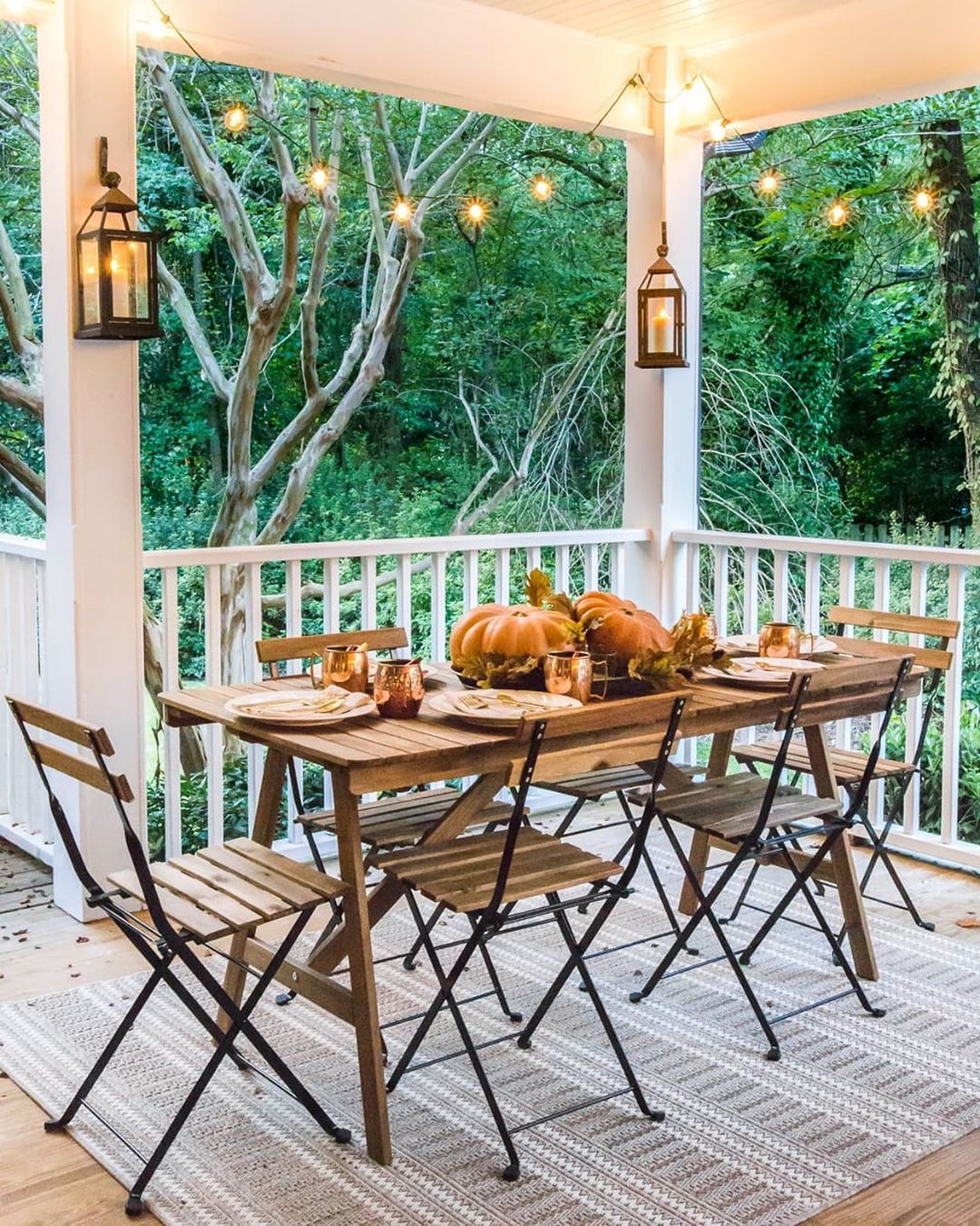 small table on a patio with string lights hanging between posts photo by Instagram user @blesserhouse
