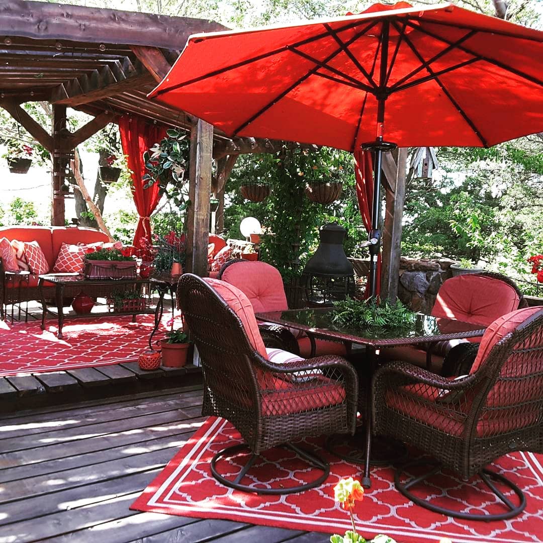 back deck with multiple seating areas and an umbrella photo by Instagram user @debradolechek