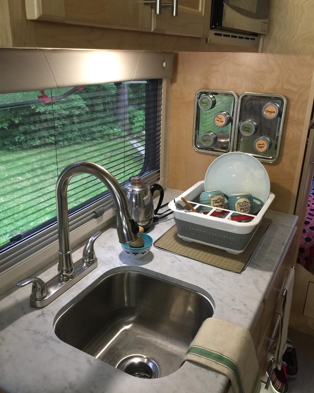 Small RV kitchen with dish organizer. Photo by Instagram user @girl_camper