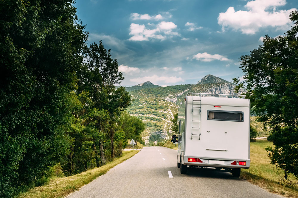 RV traveling on road in the mountains