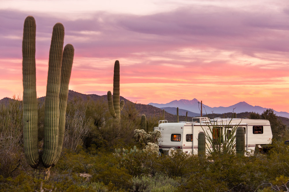 RV sitting in southwestern desert at sunset