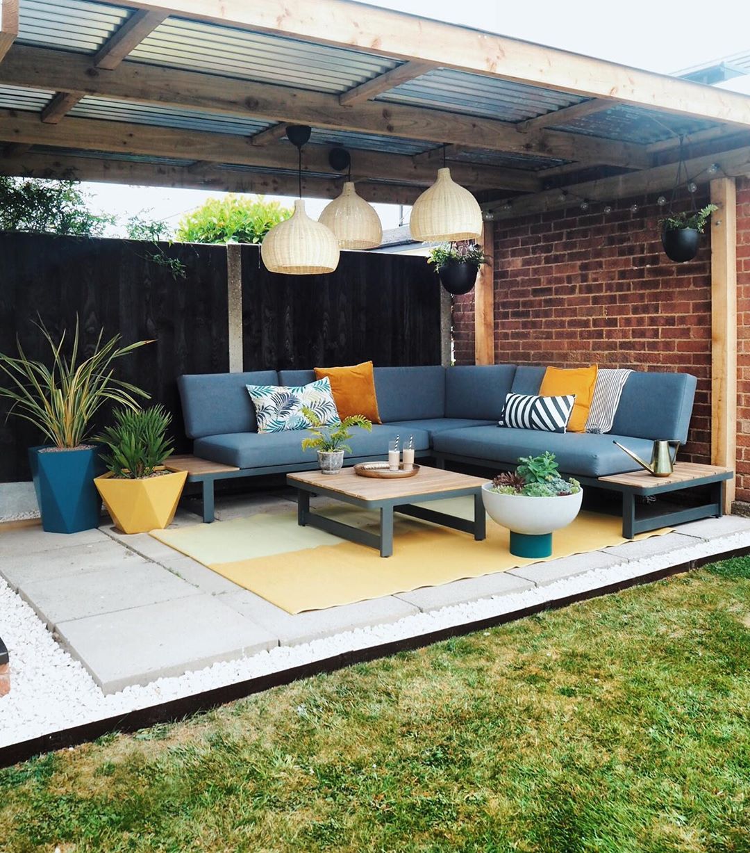 outdoor patio space with a long sectional bench seating set up with table photo by Instagram user @apogee_interiors