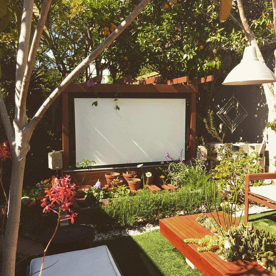 outdoor projection screen set up in backyard area photo by Instagram user @thehorticult