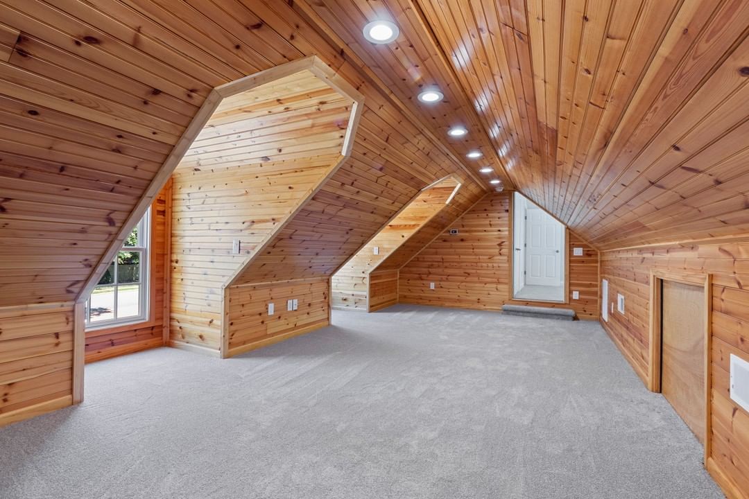 Finished Attic Space with Wood Panel Walls and Carpet Floor. Photo by Instagram user @benivinsmedia