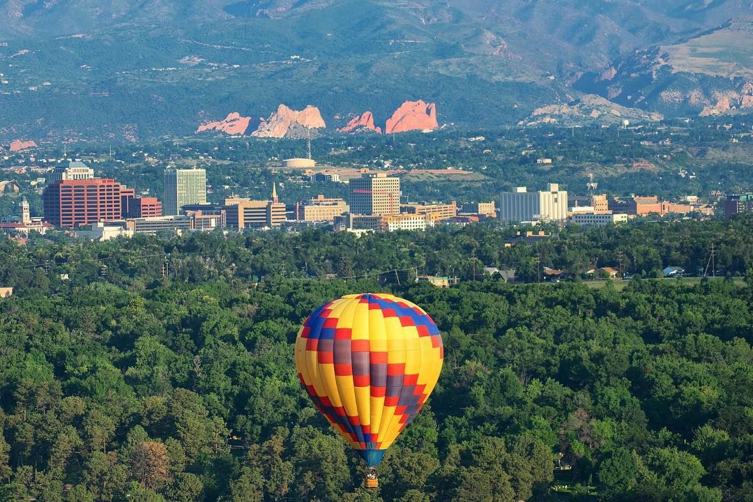 View of Colorado Springs from a drone with a hot air balloon. Photo by Instagram user @visitcos.