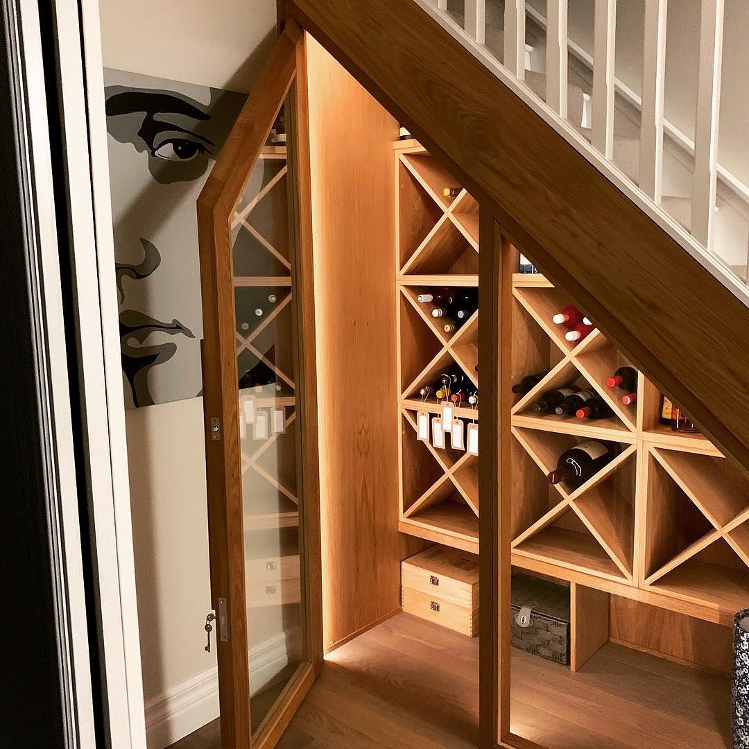 Wine storage room with glass doors under the stairs.