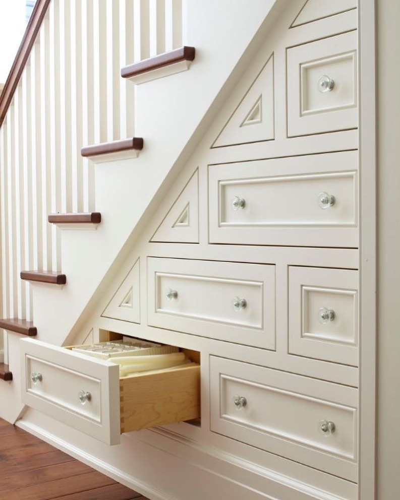 Small drawers installed beneath the stairs with linens held in each.