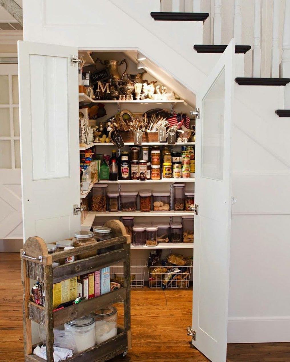 Kitchen pantry with rolling cart under the stairs.