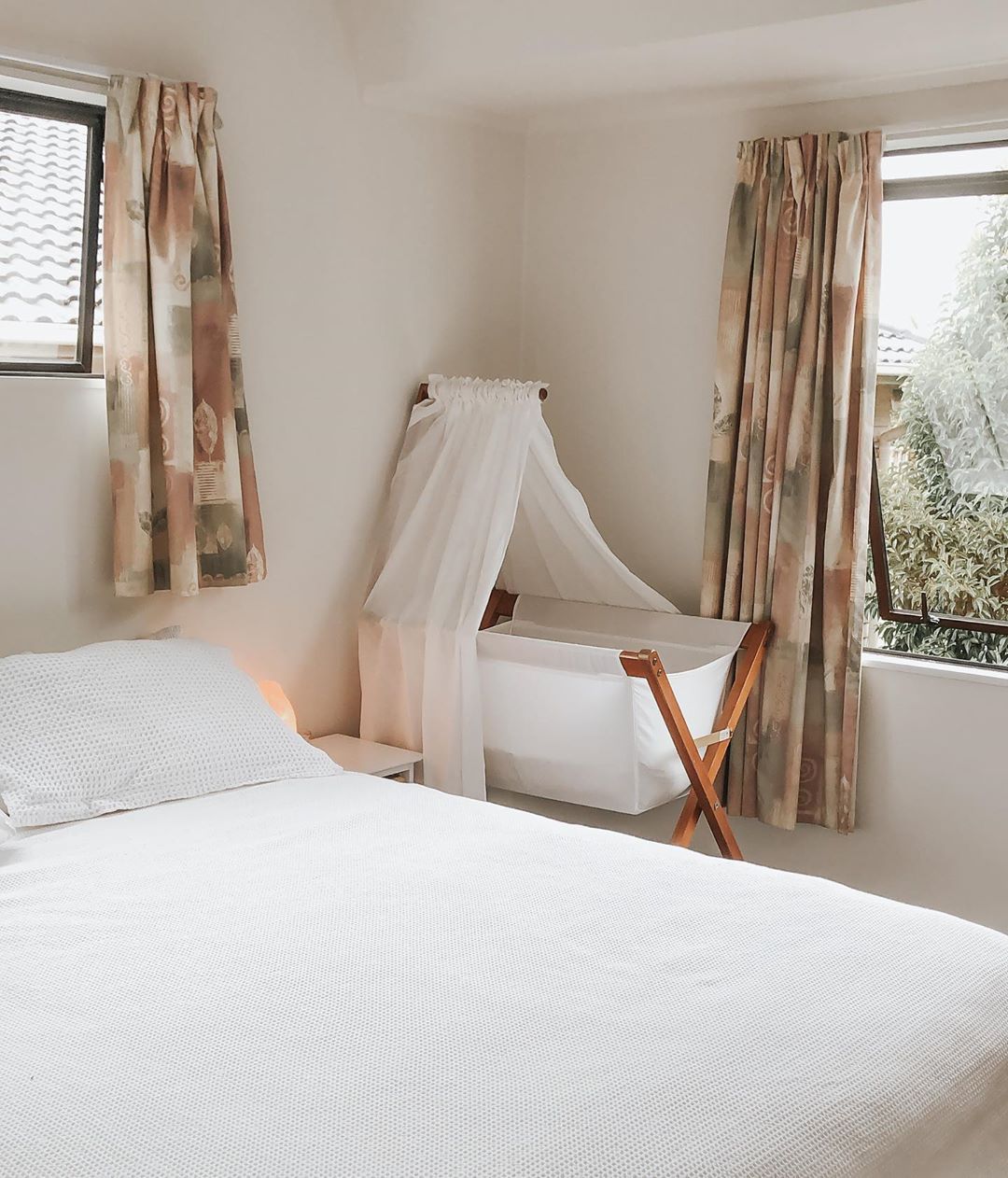 Minimalist master bedroom with baby bassinet. Photo by Instagram user @raacheljane