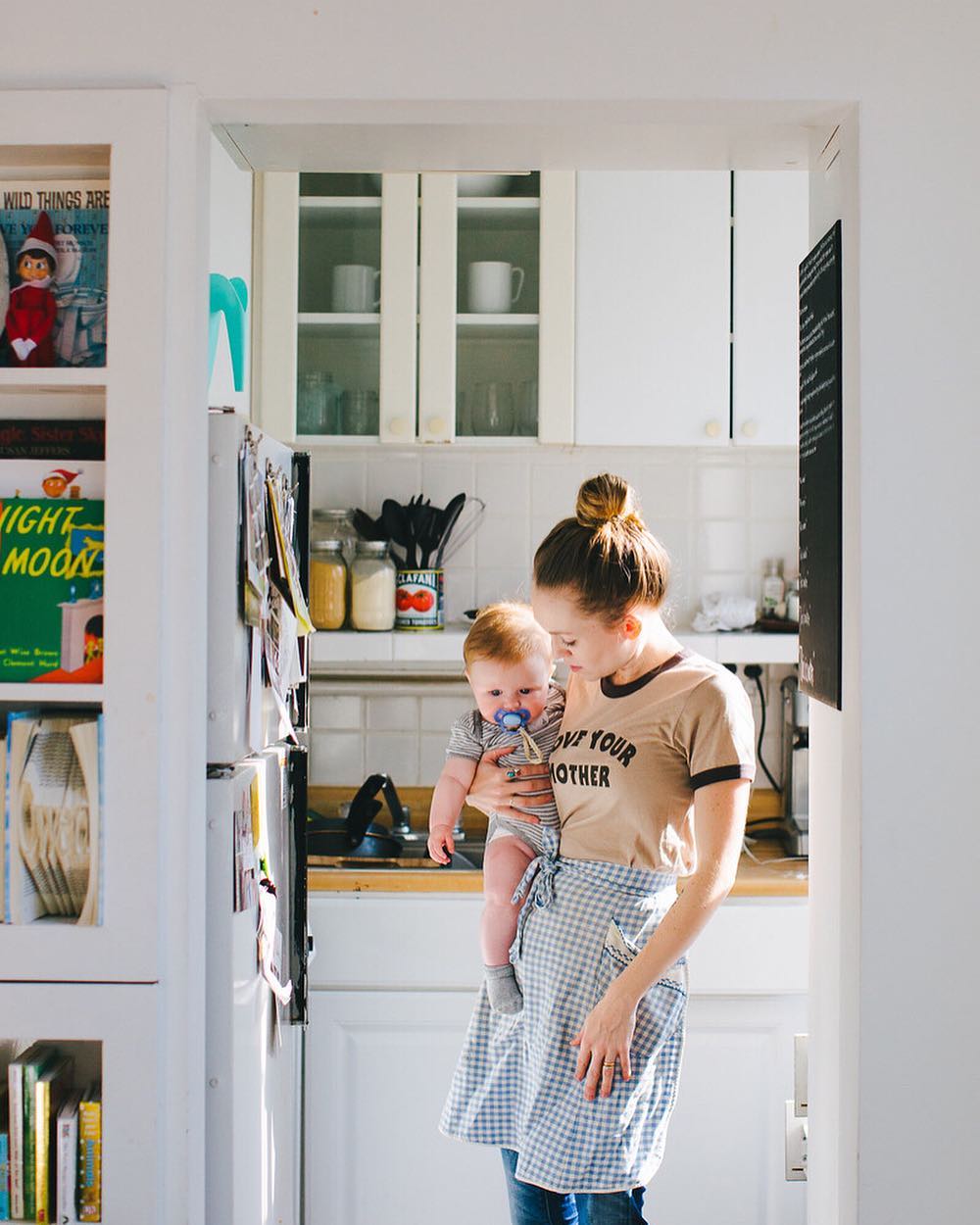 Woman Holding Her Baby Inside Her Apartment Kitchen in Brooklyn. Photo by Instagram user @hailey.marie.andresen