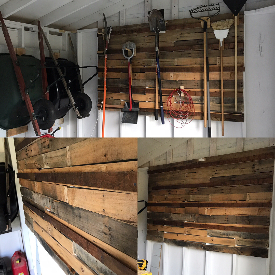 wheelbarrow hung up on shed wall next to pallet wall with tools photo by Instagram user @heatskymakershop