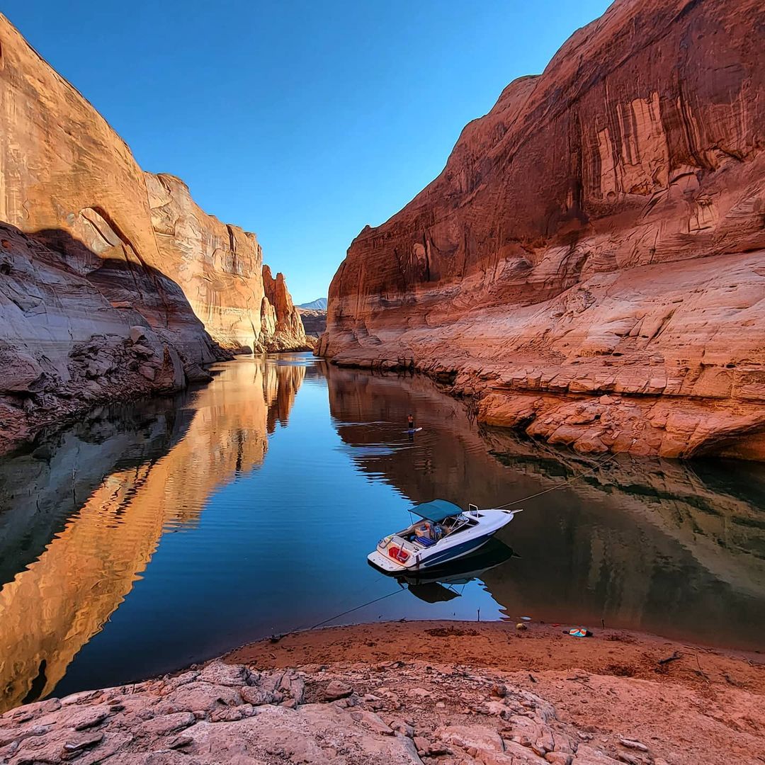 Boat Sitting in the Water in Lake Powel at Glen Canyon. Photo by Instagram user @therandimae