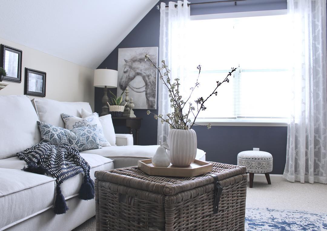 small room with white couch and wicker coffee table in middle of the room photo by Instagram user @citycottagechic