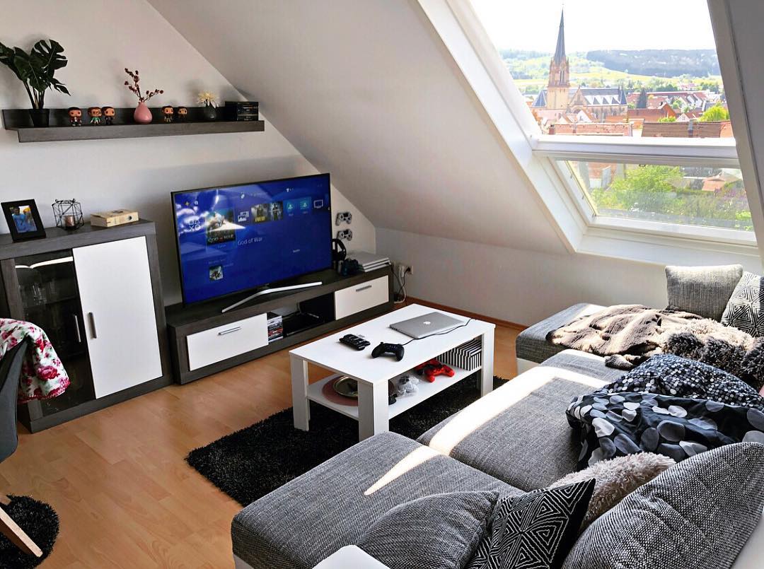 small room with gray couch and gaming set up with tv and controllers photo by Instagram user @barrysgame