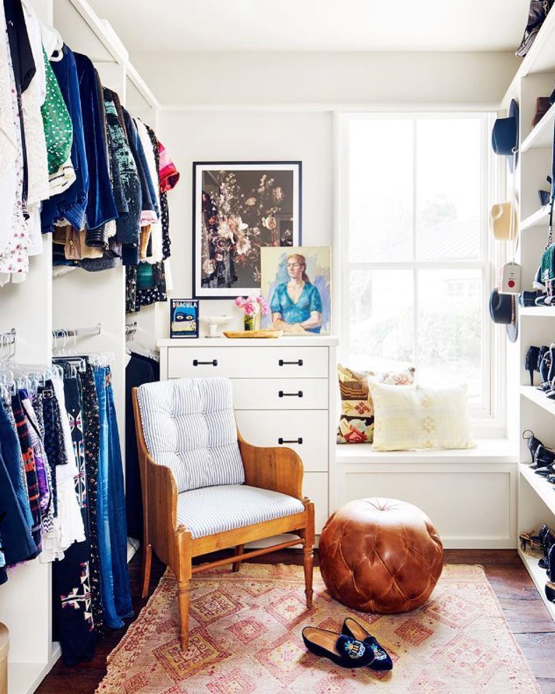 walk in closet with small chair and ottoman with dresser in the corner photo by Instagram user @house_of_merci