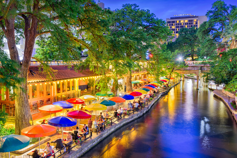 San Antonio river walk lit up at nighttime with people each outside