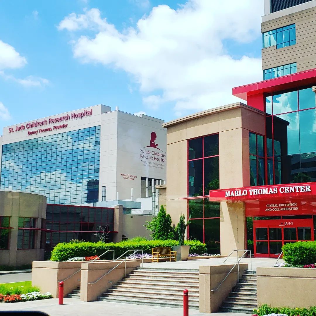 St. Judge Children's Research Hospital entrance with stone steps, red overhang, and glass windows in Memphis on a sunny day. Photo by Instagram user @cguzik05