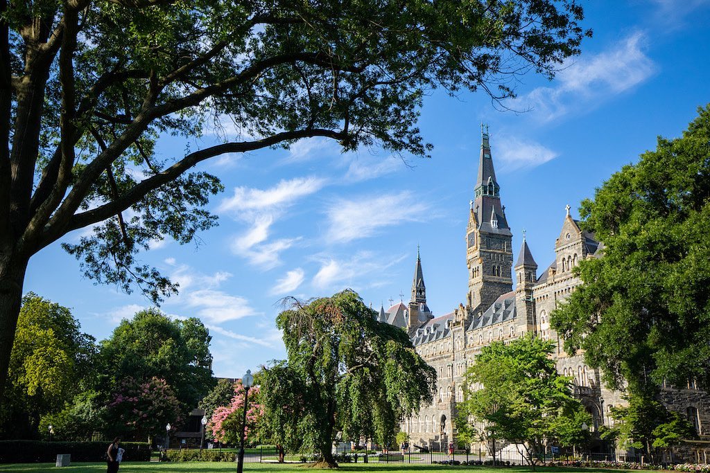 Image of the green at Georgetown University with historic building in the background. Photo by Instagram User @georgetownuniverstiy