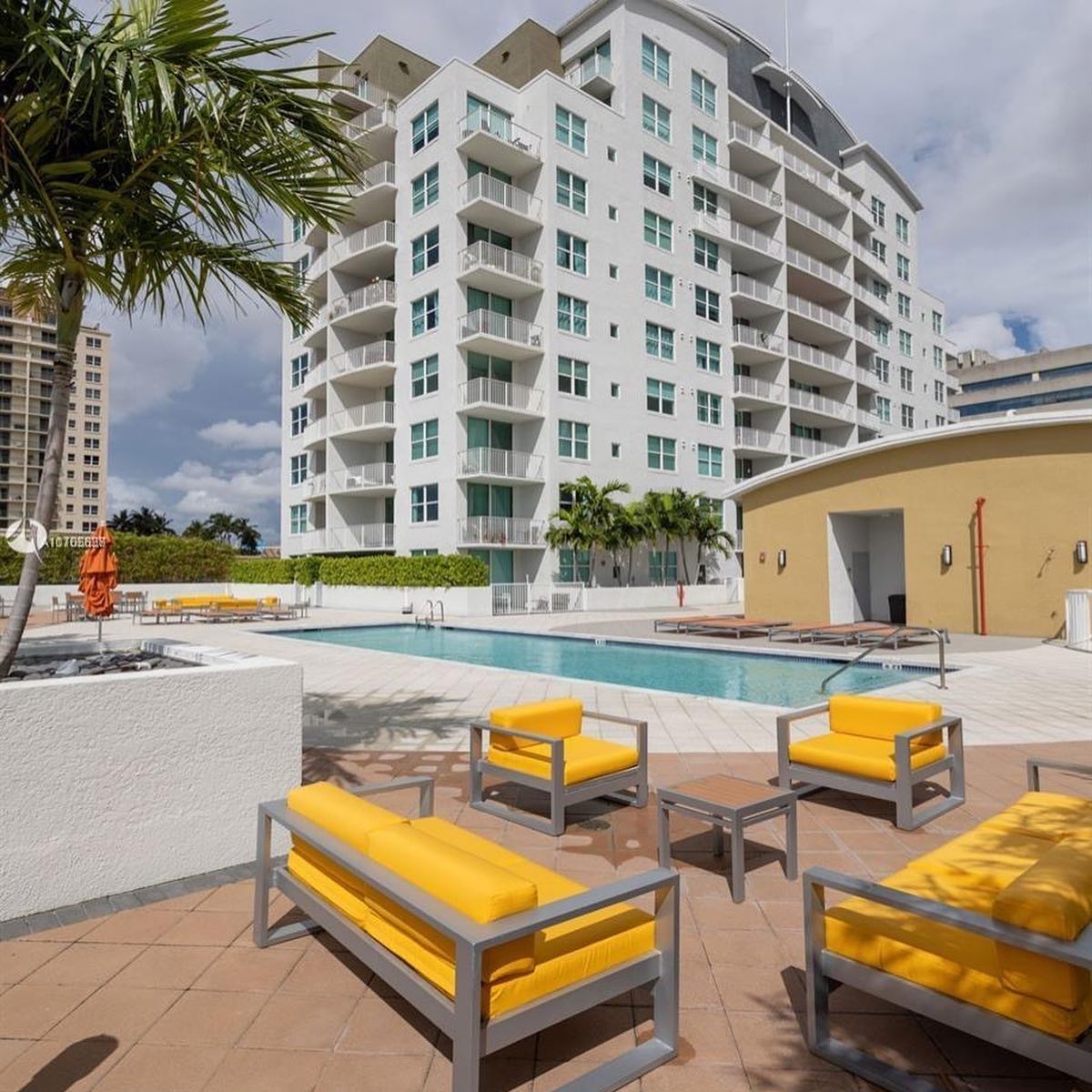 Coral Way condos with pool and yellow lounge seating. Photo by Instagram user @alexandraanovoo