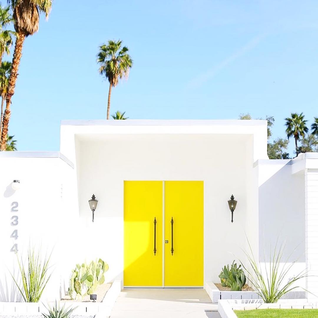 Bright yellow doors on modern house. Photo by Instagram user @goldenstrandjewelry