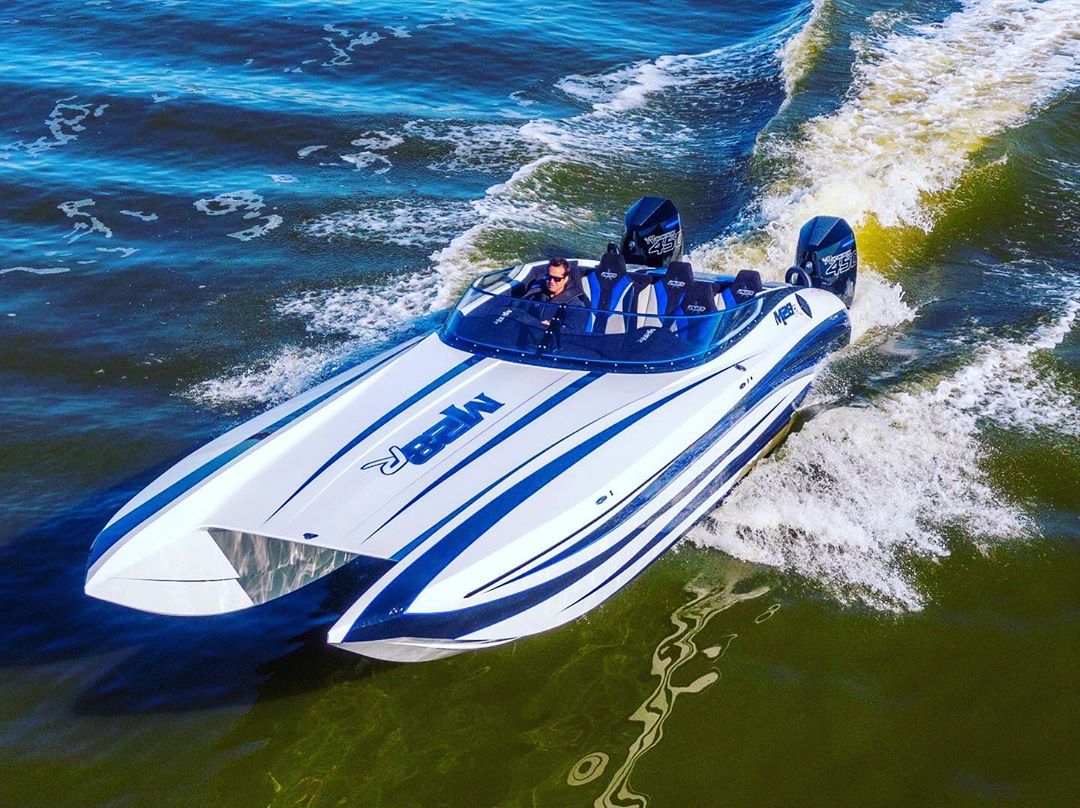 white and blue high performance boat driving in the water photo by Instagram user @andersonracingdcbm28
