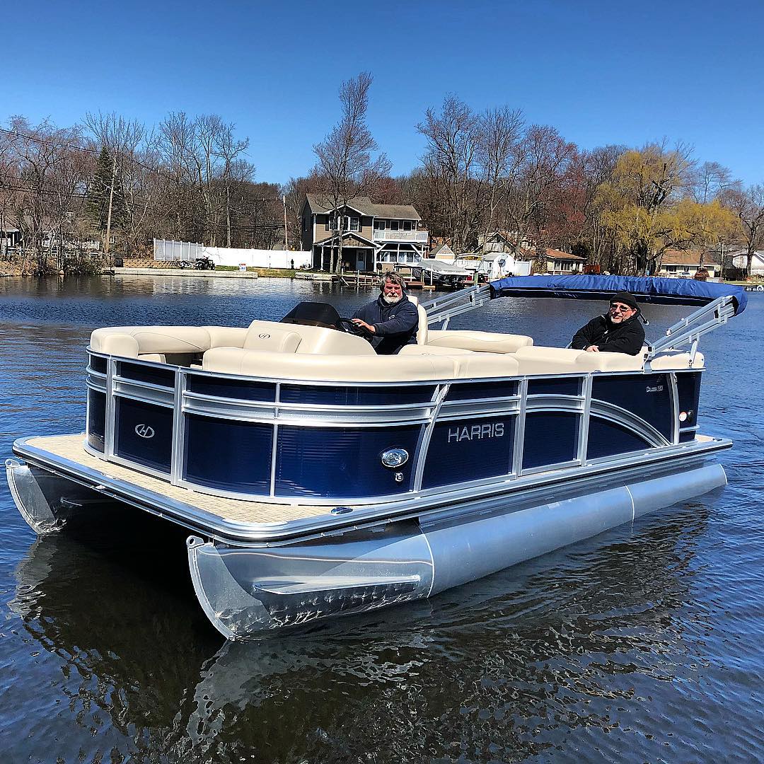 pontoon boat in water with two people aboard photo by Instagram user @marinemaxlakehopatcong