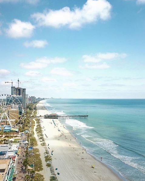 Ariel photo of the beach with ferris wheel to left and ocean to the right photo via @mymyrtlebeach