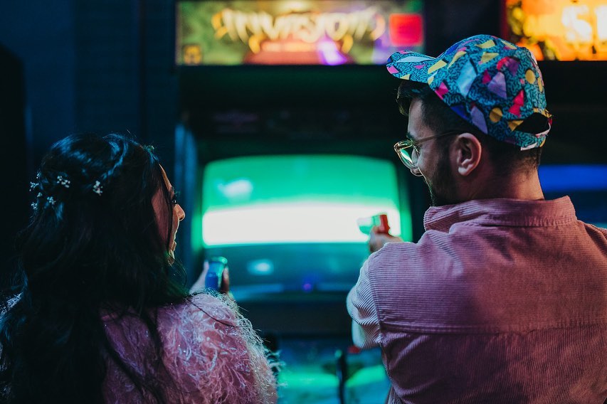 two people looking at each other and playing a vintage arcade game. Photo by Instagram user @flojabbani