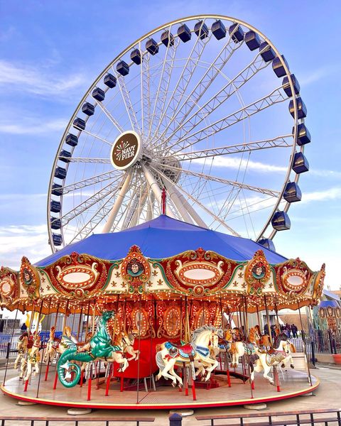 Ferris Wheel and Merry Go Round with light blue sky at Navy Pier Photo via @navypierchicago
