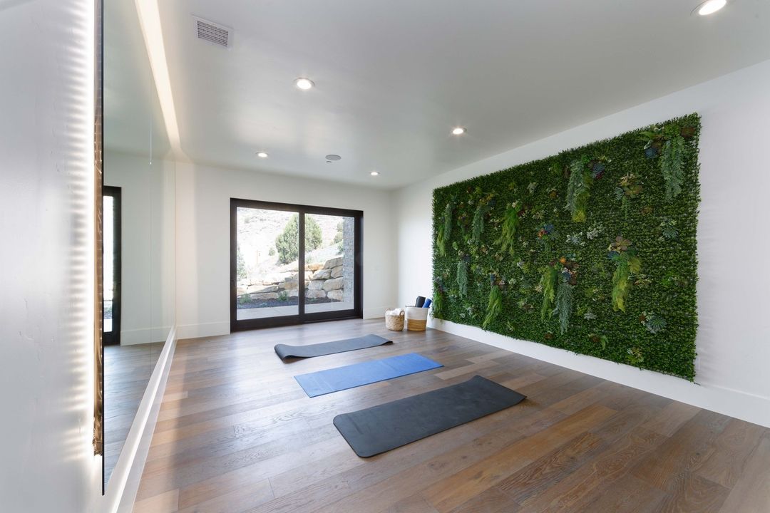 Home gym for yoga with vinyl flooring and live plant wall. Photo by Instagram user @purehavenhomes.