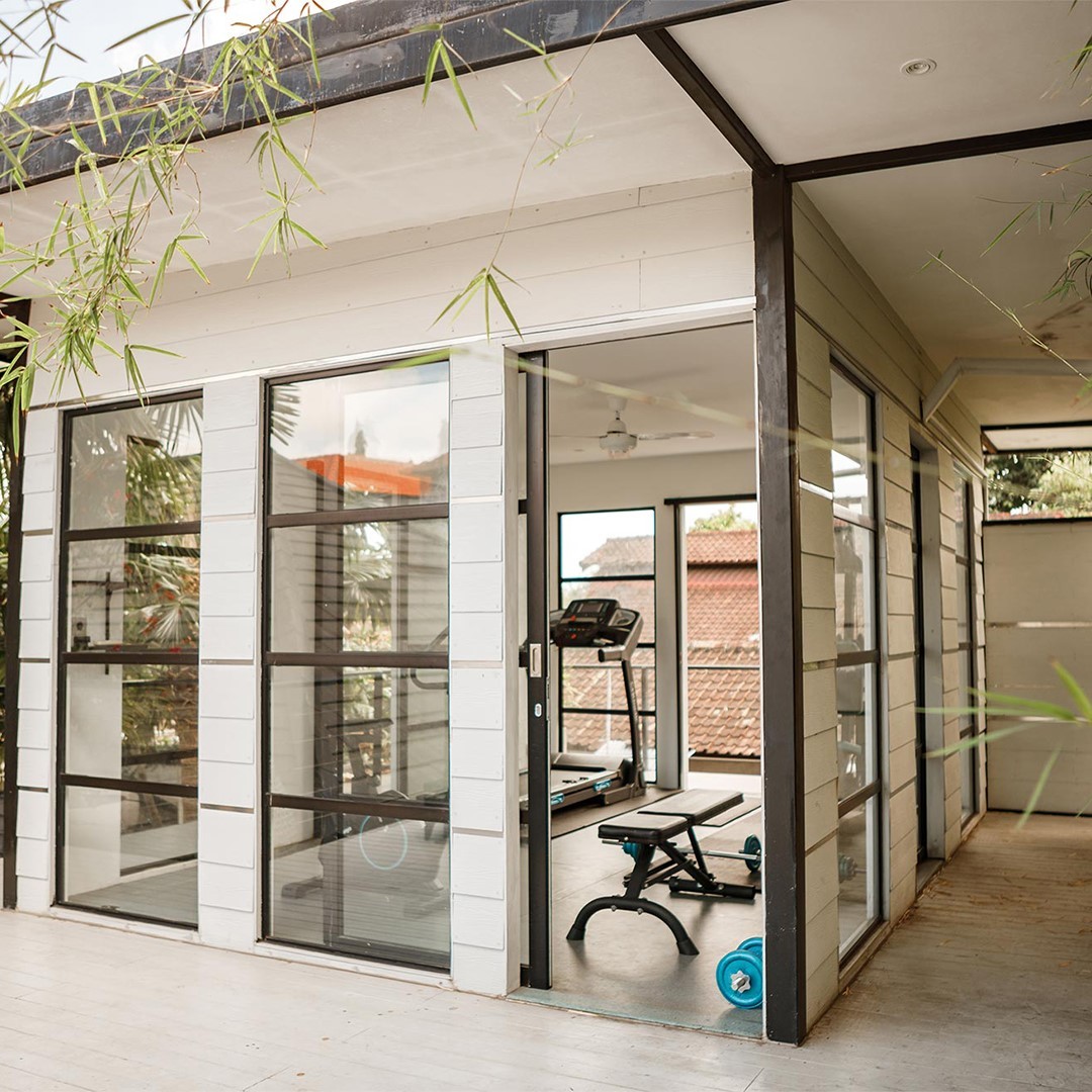 indoor-outdoor home gym with sliding door and lots of windows. Photo by Instagram user @solohomegym.