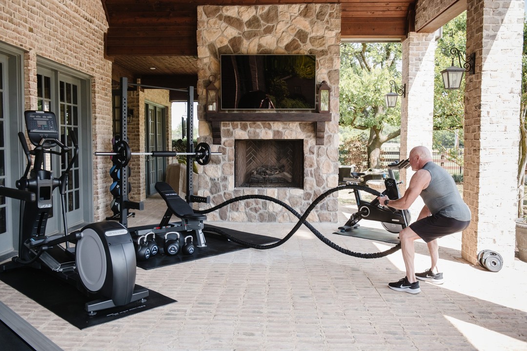 Outdoor home gym with man using battle ropes. Photo by Instagram user @topfitnessstore.