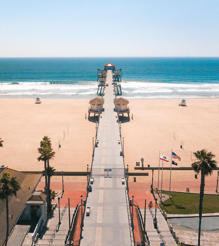 Boardwalk over tan-red sand looking out toward the ocean. Photo by Instagram user @mmaaddzz