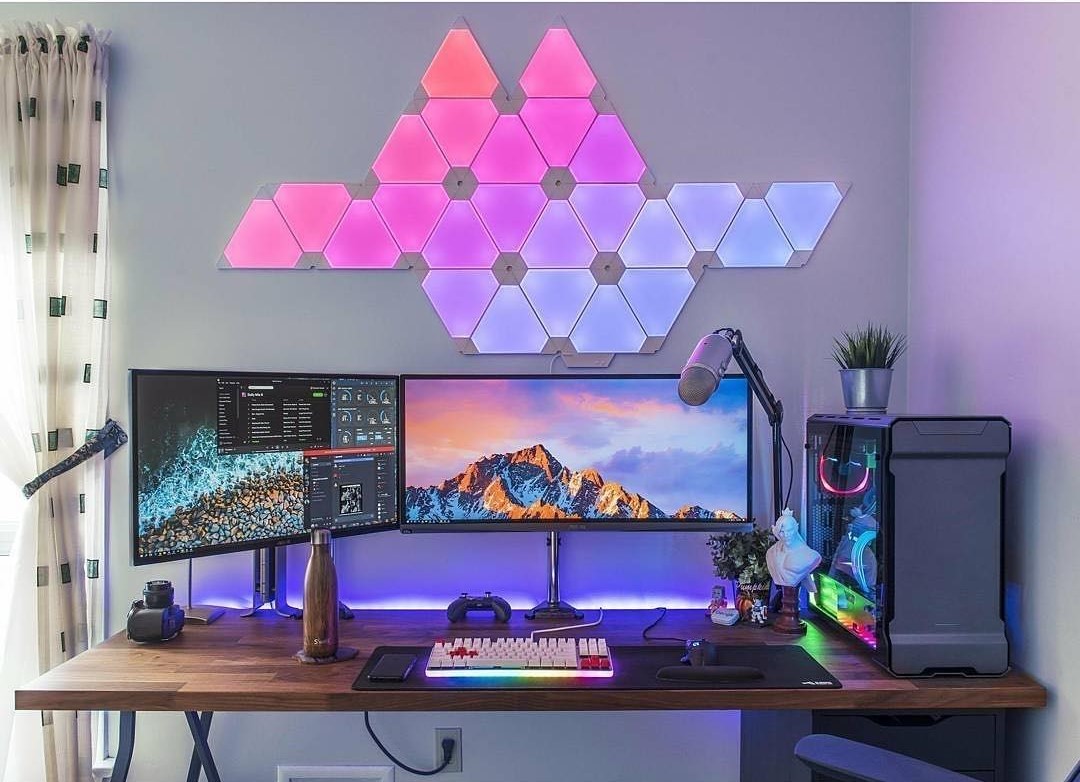 neon geometrical shape light hanging on wall above computer desk