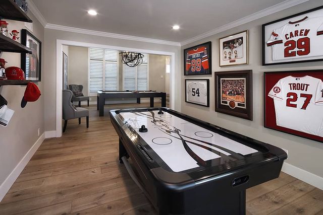 Sports Themed Game Room With Air Hockey Table and Jersey's on the Wall. Photo by Instagram user @designsbymilenka